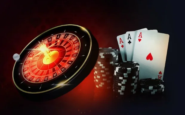 Roda de roleta iluminada ao lado de pilhas de fichas pretas e cartas de ás, sobre fundo vermelho escuro
